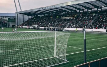 Stadion sepak bola dengan tribun penuh penonton