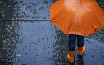 Gambar ilustrasi anak kecil berpayung di tengah hujan