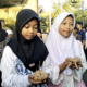 Dua anak menunjukkan "kupat jembut" dalam tradisi Syawalan yang digelar di Jalan Tlogomulyo. (Adher/beritajateng.tv)